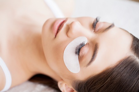 Woman Eye with Long Eyelashes. Beautiful Young Woman During Eyelash Extensionの写真素材