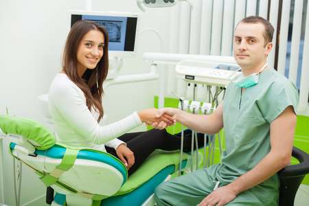 Patient in dentistry. Pretty woman visiting her dentist in clinicの写真素材