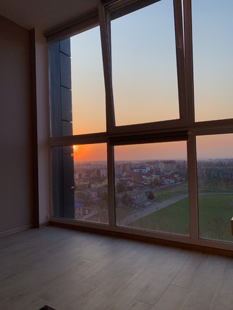 Panoramic windows overlooking beautiful golden sunset. View from home window