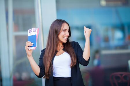 Travel. Woman holding two air ticket in abroad passport near airportの写真素材