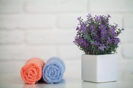 Fluffy bath towels on light wooden table with decor and white backgroundの写真素材