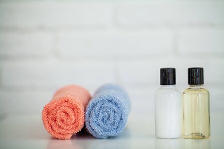 Cosmetic products and cotton towels on white wooden table in beauty salonの写真素材