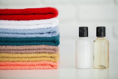 Cosmetic products and cotton towels on white wooden table in beauty salonの写真素材