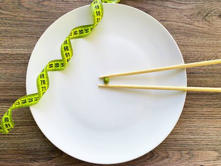 Cropped image pea on white plate, with fork and measuringの写真素材