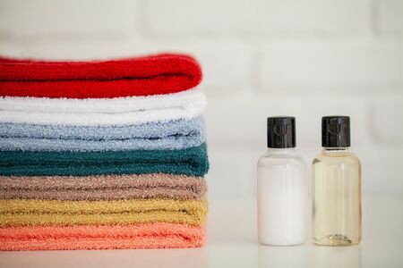 Cosmetic products and cotton towels on white wooden table in beauty salonの写真素材