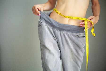 Diet. Woman in Sportswear Measuring Her Waist. Dieting conceptの写真素材