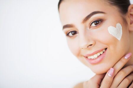 Skin Care. Beautiful model applying cosmetic cream treatment on her faceの写真素材