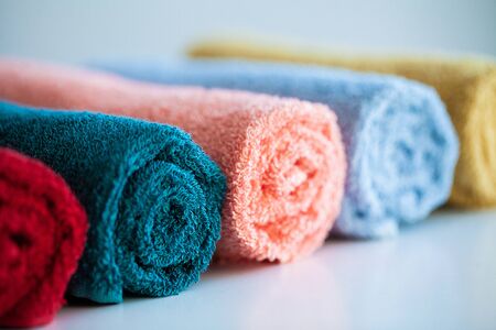 Colored towels on white table with copy space on bath room background.の写真素材
