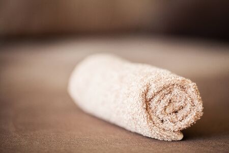 Towel on brown bed with copy space in living room.の写真素材