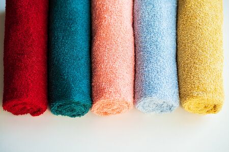 Colored towels on white table with copy space on bath room background.の写真素材