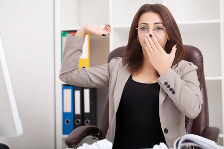 Young beautiful business woman suffering stress working at office asking for help feeling tiredの写真素材