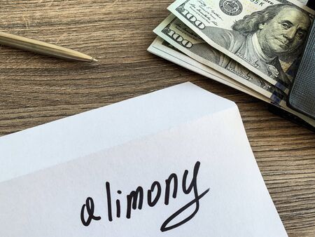 Payments alimony. White envelope with sign alimony and money.の写真素材