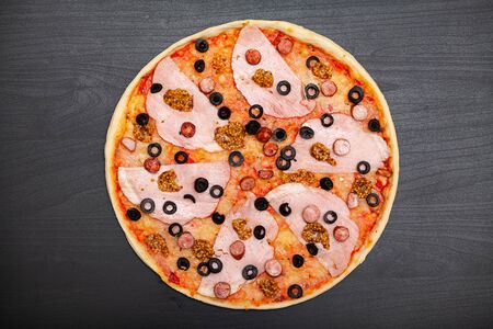 Tasty pizza with various flavored ingredients on a dark backgroundの写真素材