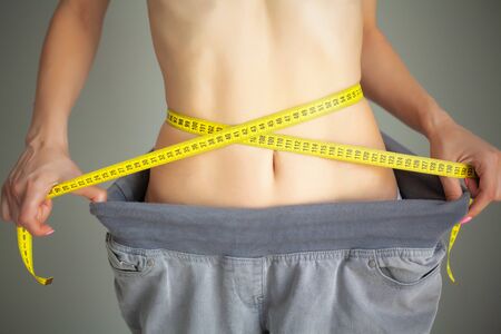 Diet. Woman in Sportswear Measuring Her Waist. Dieting conceptの写真素材