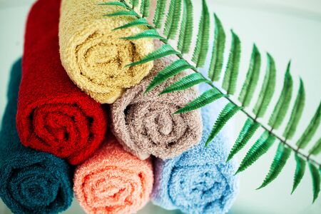 Colored towels on white table with copy space on bath room backgroundの写真素材