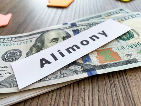 Payments alimony. Pile Dollars with sign alimony and money. Divorce and separation conceptの写真素材