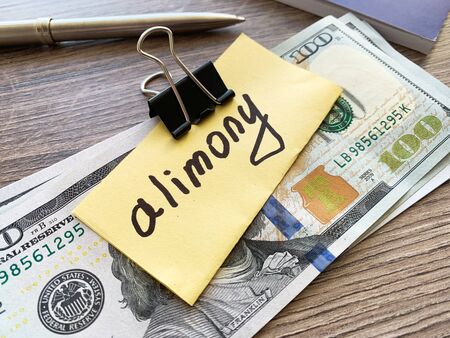 Payments alimony. Pile Dollars with sign alimony and money. Divorce and separation conceptの写真素材