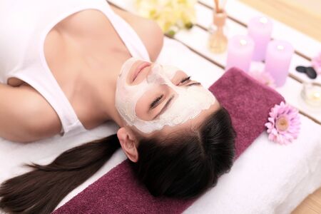 Spa therapy for young woman having facial mask at beauty salon - indoorsの写真素材