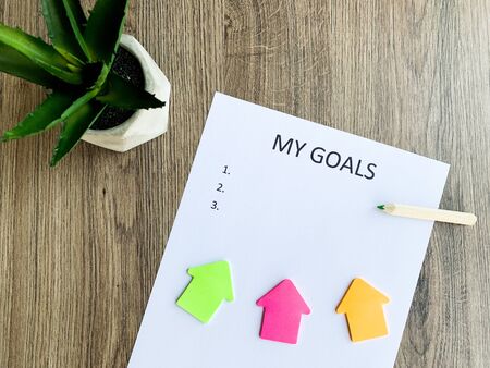 Clipboard with my goals on wood desk.