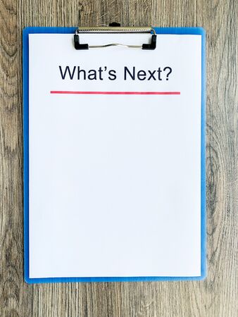 Clipboard with text whats next on wood desk.の写真素材