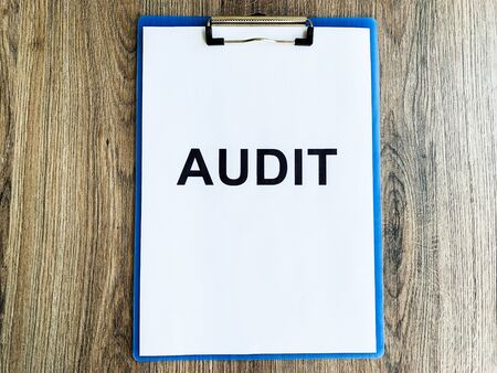 Clipboard with text audit on wood desk.の写真素材