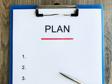 Clipboard with text plan on wood desk.の写真素材