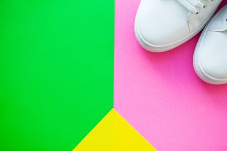 Pair of new stylish white sneakers on green pink background.の写真素材