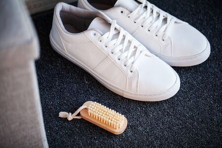 Pair of new stylish white sneakers on floor at home.の写真素材