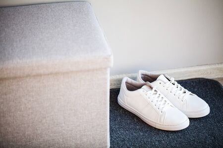 Pair of new stylish white sneakers on floor at home.の写真素材