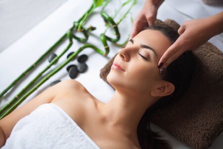 Top view of pretty woman laying in spa salon with closed eyes and relaxedの写真素材