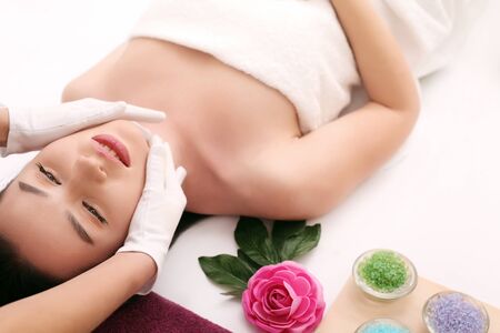 Beautiful young woman receiving facial massage in spa salonの写真素材