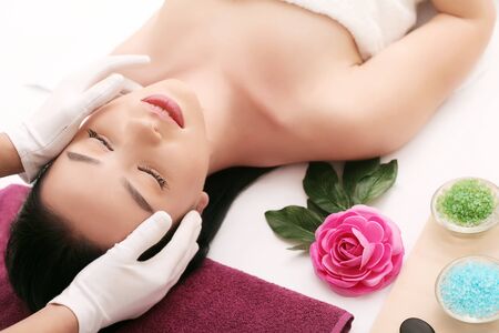 Beautiful young woman relaxing with head massage.の写真素材