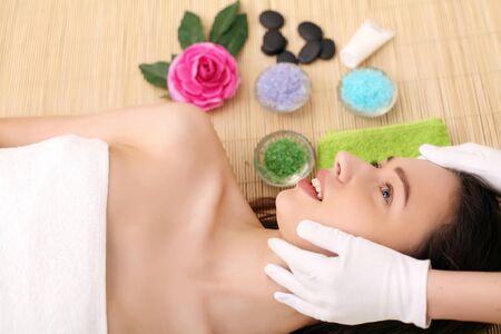 Beautiful young woman receiving facial massage in spa salonの写真素材