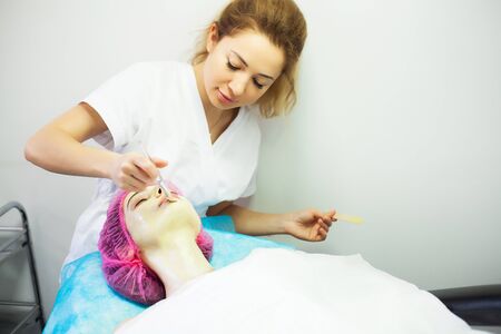 Spa therapy for young woman having facial mask at beauty salon.の写真素材