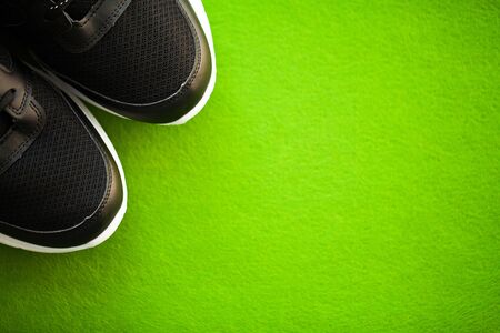 Pair of new stylish sneakers on green background.の写真素材