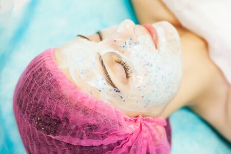 Spa therapy for young woman having facial mask at beauty salon.の写真素材