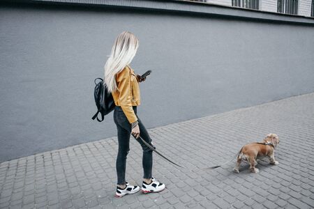 Noise and vintage style. Young girl with dog walks in the park and enjoys the beautiful summer dayの写真素材