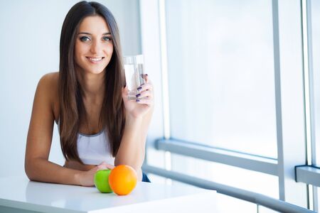 Beautiful Smiling Woman Taking Vitamin Pill. Dietary Supplementの写真素材