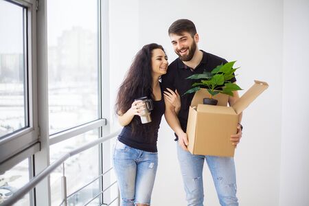 Couple showing keys to new home hugging looking at camera