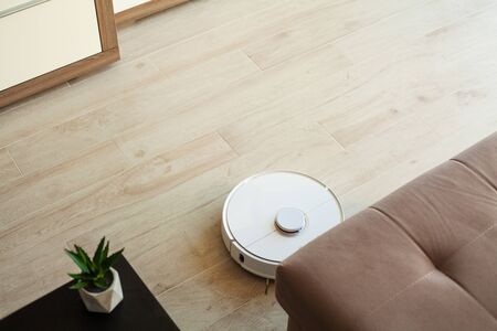 Robot vacuum cleaner performs automatic cleaning of the apartment at a certain time. Smart homeの写真素材