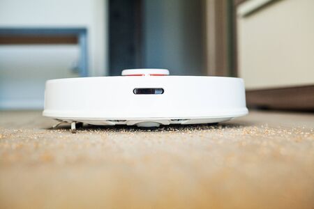 Robot vacuum cleaner performs automatic cleaning of the apartment at a certain time. Smart home.の写真素材