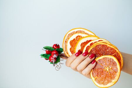 Woman in hand holds Christmas decorations on light backgroundの写真素材