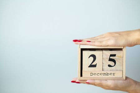 Woman in hand holds Christmas decorations on light backgroundの写真素材