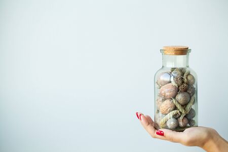 Woman in hand holds Christmas decorations on light backgroundの写真素材