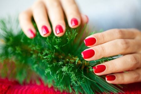Red Christmas manicure make in beauty studio on Christmas background.の写真素材