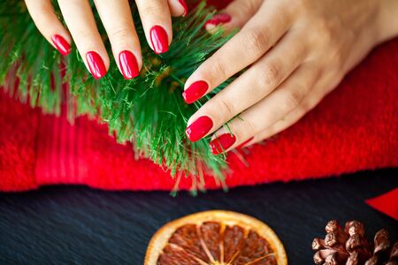 Red Christmas manicure make in beauty studio on Christmas background.の写真素材