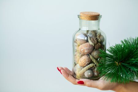 Woman in hand holds Christmas decorations on light backgroundの写真素材