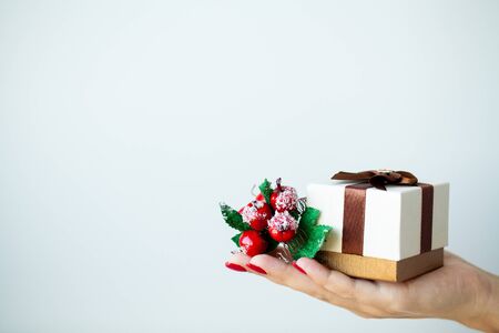 Woman in hand holds Christmas decorations on light backgroundの写真素材
