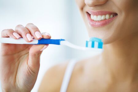 Beautiful Smiling Woman Brushing Healthy White Teeth With Brush. High Resolution Imageの写真素材