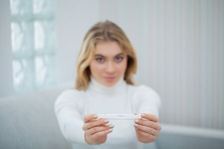 Happy woman Looking at a Pregnancy Test after result.